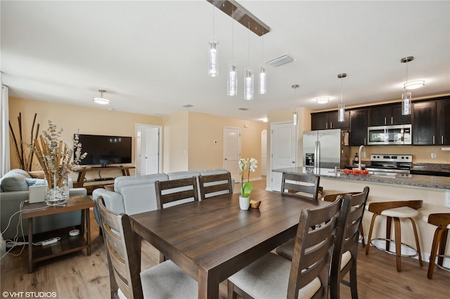 dining area with sink and light hardwood / wood-style flooring