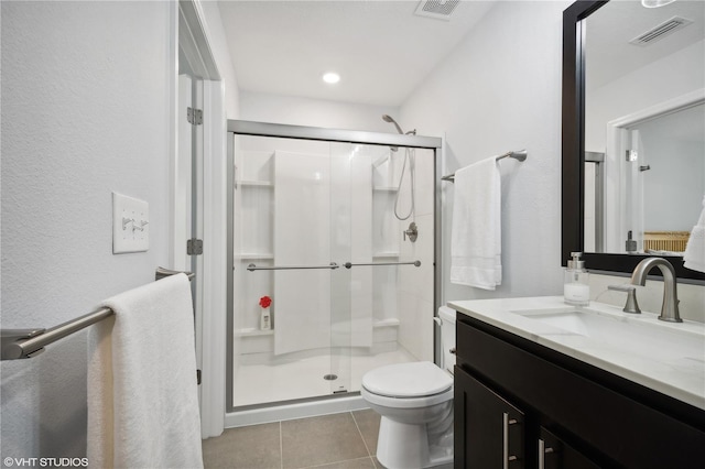 bathroom featuring vanity, toilet, a shower with shower door, and tile patterned flooring