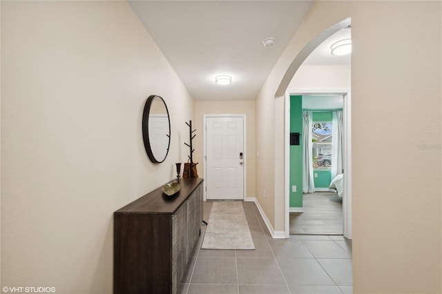 doorway to outside with light tile patterned flooring