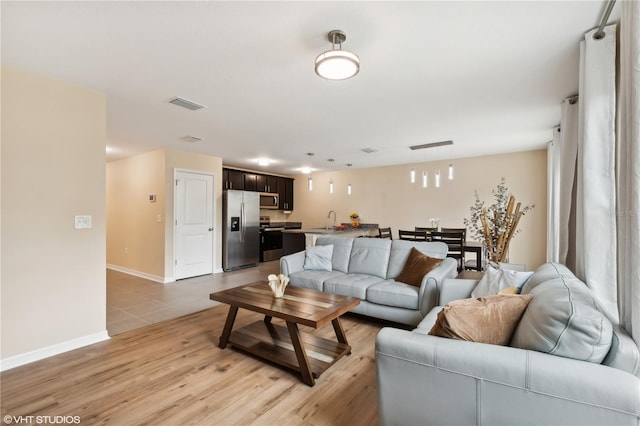 living room with sink and light hardwood / wood-style floors