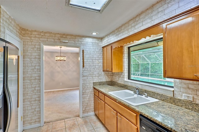 kitchen with a sink, black dishwasher, stainless steel fridge, light tile patterned flooring, and light colored carpet