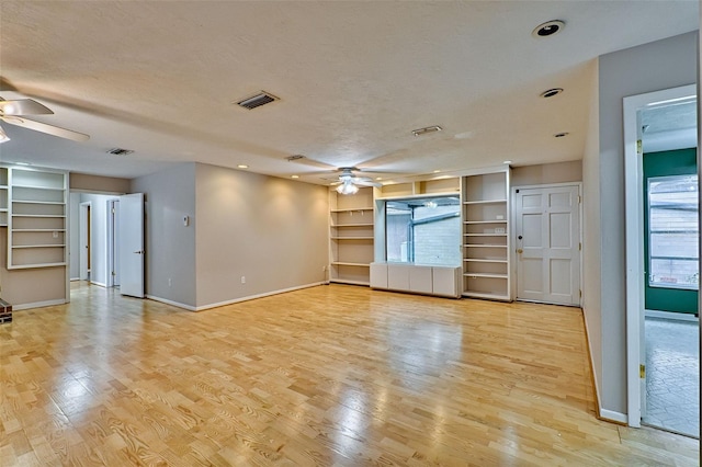 unfurnished living room featuring a ceiling fan, visible vents, light wood finished floors, and a textured ceiling