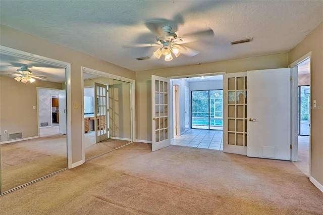 spare room featuring visible vents, french doors, a ceiling fan, and carpet floors