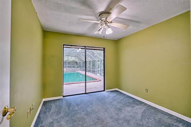 carpeted spare room with a textured ceiling, baseboards, and ceiling fan