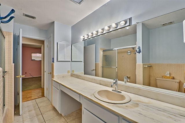 bathroom with visible vents, vanity, a shower stall, and tile patterned flooring