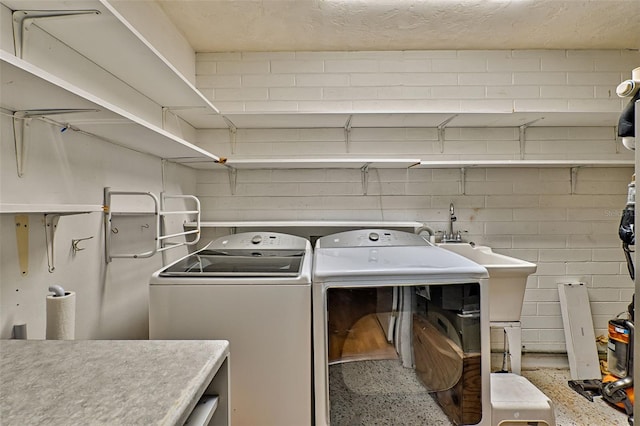 laundry room featuring washer and dryer, laundry area, and concrete block wall