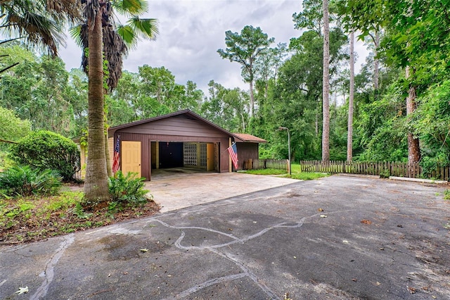 garage with driveway and fence