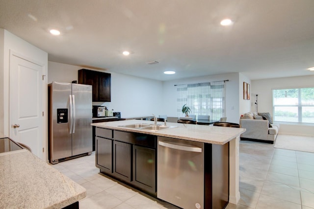 kitchen with dark brown cabinets, a kitchen island with sink, sink, and stainless steel appliances