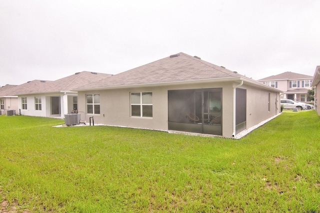 rear view of house with a yard and central air condition unit