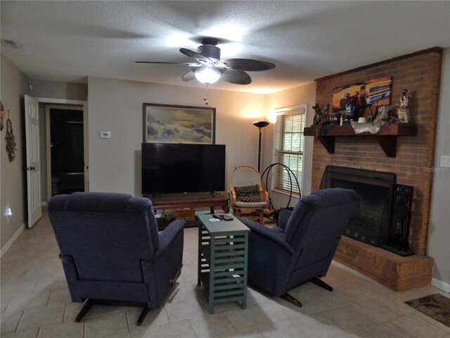 tiled living room with a textured ceiling, a brick fireplace, and ceiling fan