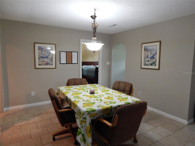 tiled dining area featuring a textured ceiling