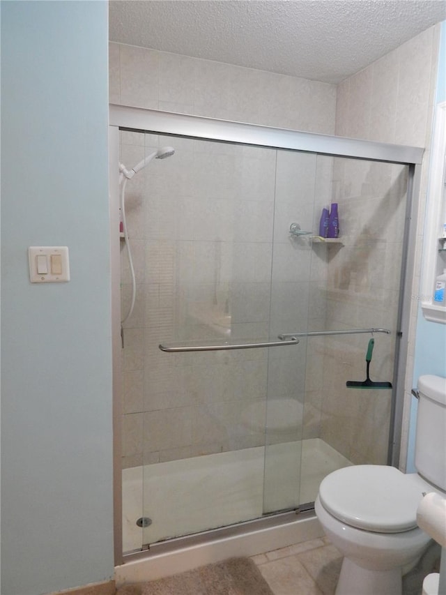 bathroom featuring walk in shower, toilet, a textured ceiling, and tile patterned floors