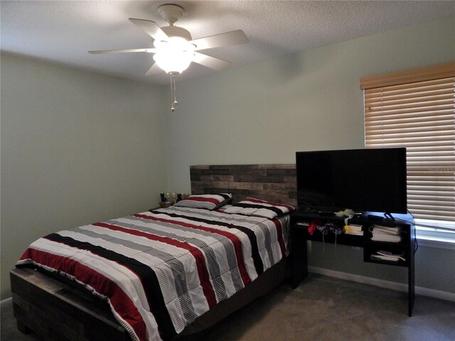 carpeted bedroom featuring ceiling fan and a textured ceiling