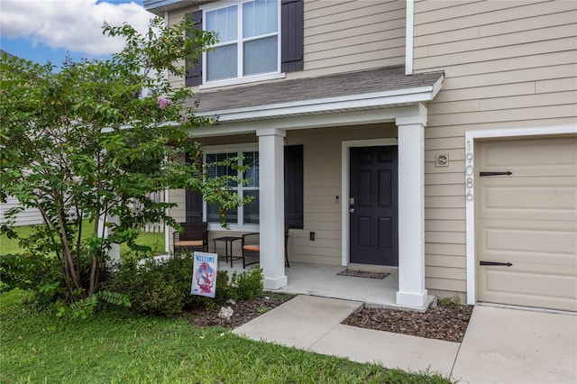 entrance to property featuring a garage and covered porch