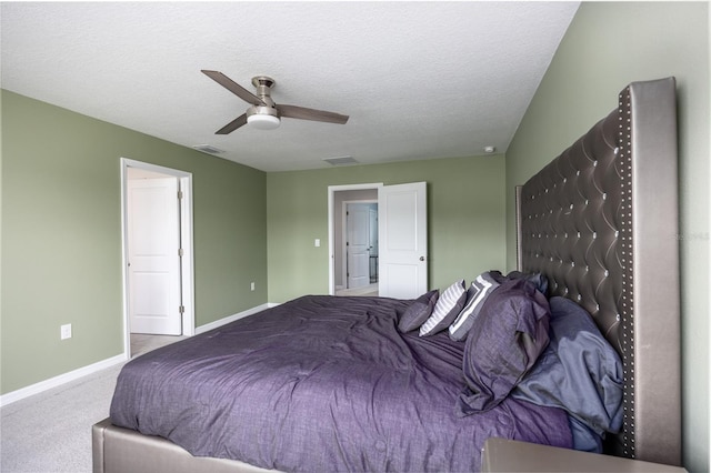 carpeted bedroom with ceiling fan and a textured ceiling