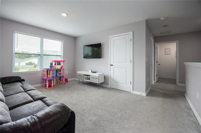 living room featuring light carpet and a textured ceiling