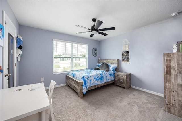 carpeted bedroom with ceiling fan and a textured ceiling