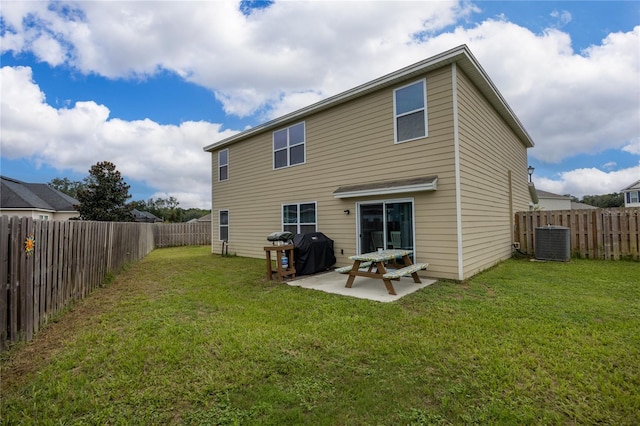 rear view of property with cooling unit, a patio area, and a yard