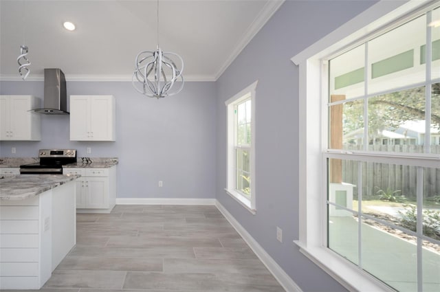 kitchen featuring hanging light fixtures, wall chimney exhaust hood, electric range, and white cabinets