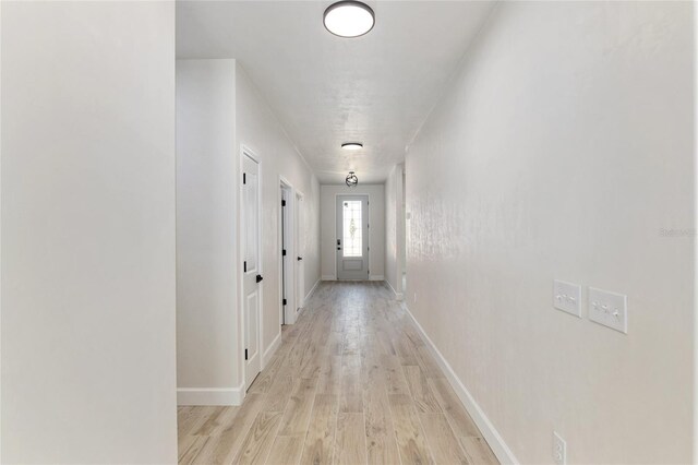 corridor with light hardwood / wood-style floors