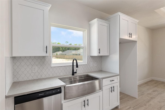 kitchen featuring light stone countertops, light hardwood / wood-style floors, dishwasher, and sink