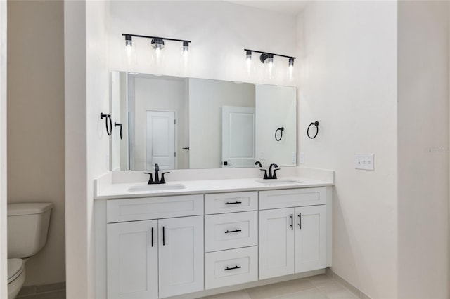 bathroom with tile patterned flooring, vanity, and toilet