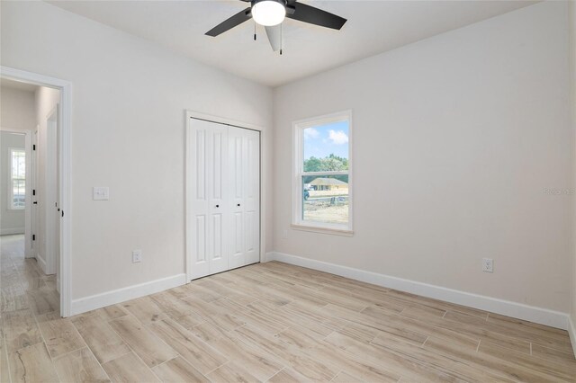 unfurnished bedroom with ceiling fan, light hardwood / wood-style flooring, and a closet