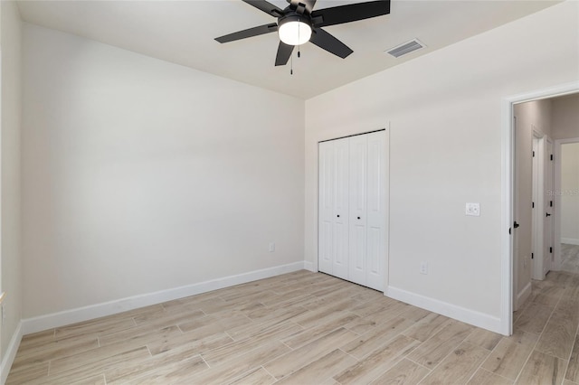 unfurnished bedroom with a closet, light hardwood / wood-style floors, and ceiling fan