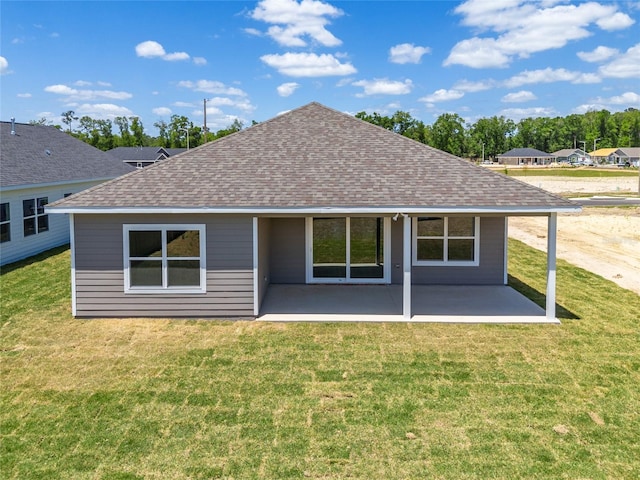 rear view of house featuring a yard and a patio