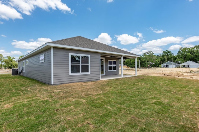 back of property with central AC unit, a yard, and a patio