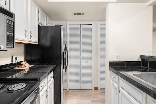 kitchen with white cabinets and light hardwood / wood-style floors