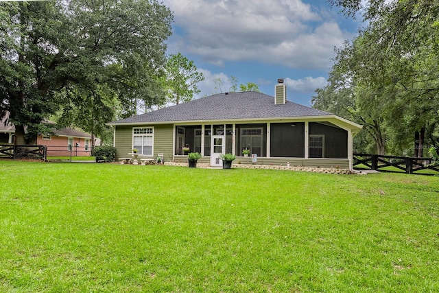 back of house with a sunroom and a yard