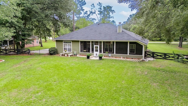 back of house with a lawn and a sunroom