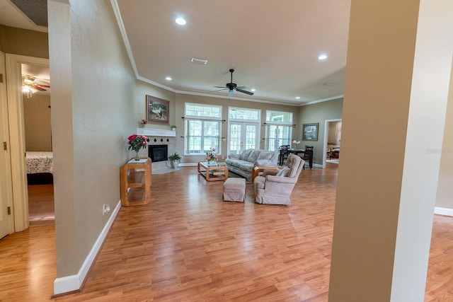 living room with ceiling fan, ornamental molding, and light hardwood / wood-style floors