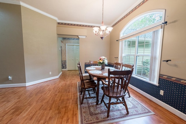 dining room featuring hardwood / wood-style flooring, ornamental molding, and a notable chandelier