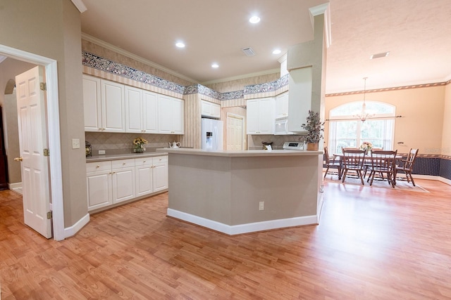 kitchen with an inviting chandelier, decorative light fixtures, light wood-type flooring, and white appliances