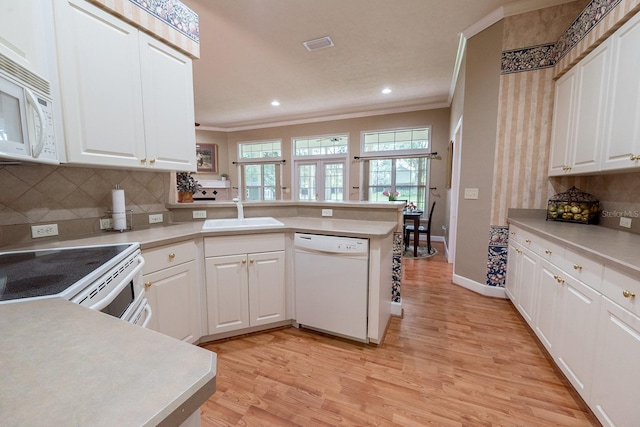 kitchen featuring light wood-type flooring, sink, white cabinets, kitchen peninsula, and white appliances