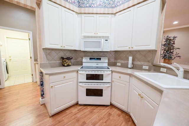 kitchen with white cabinets, sink, white appliances, light hardwood / wood-style flooring, and crown molding