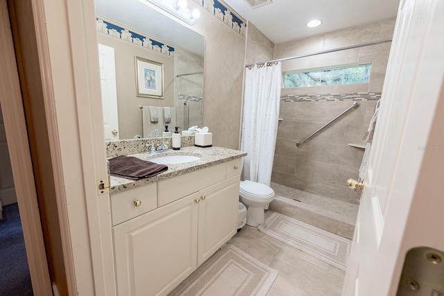 bathroom featuring walk in shower, tile patterned flooring, vanity, and toilet