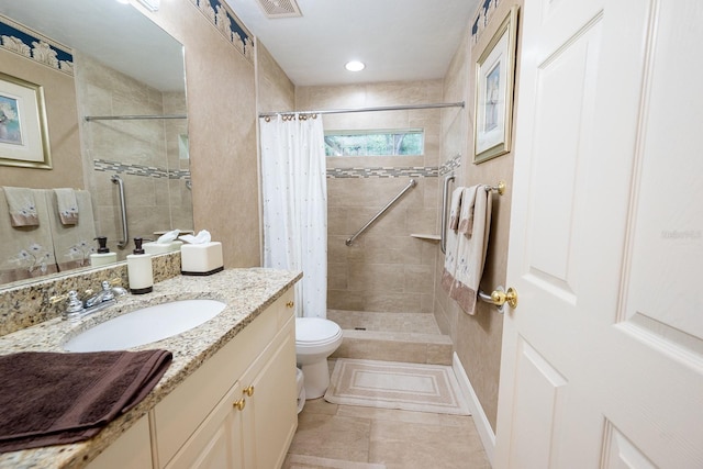 bathroom featuring tile patterned flooring, toilet, vanity, and curtained shower