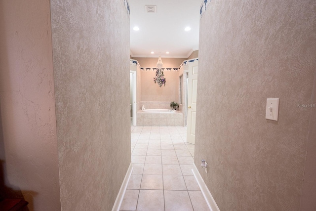 hall featuring ornamental molding and light tile patterned flooring