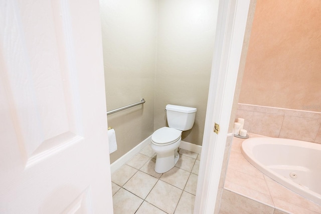 bathroom featuring a tub to relax in, tile patterned flooring, and toilet