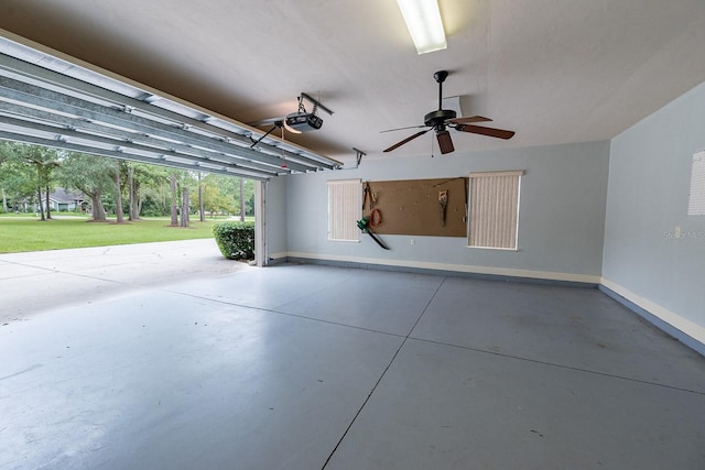 garage with a lawn, a garage door opener, and ceiling fan