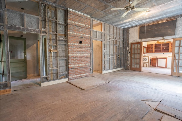 misc room with a towering ceiling, ceiling fan, and hardwood / wood-style flooring