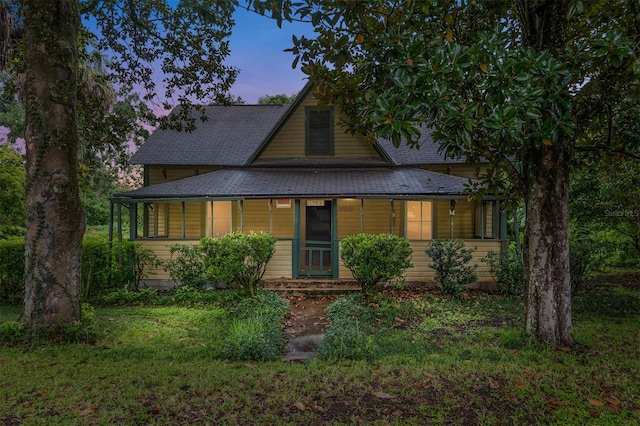 view of front of home with covered porch and a yard