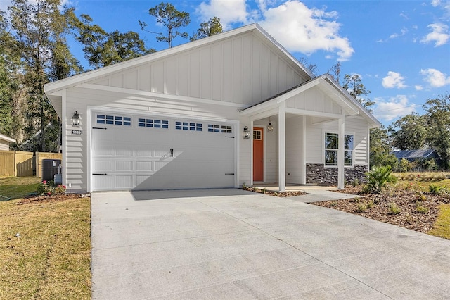 view of front of property with cooling unit, a garage, and a front lawn