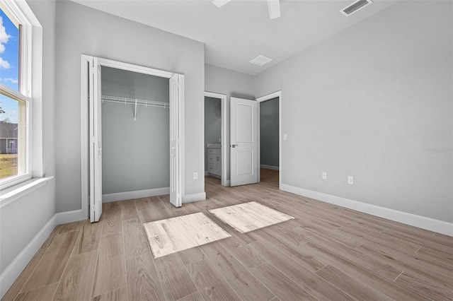 unfurnished bedroom featuring light hardwood / wood-style floors, ceiling fan, and a closet