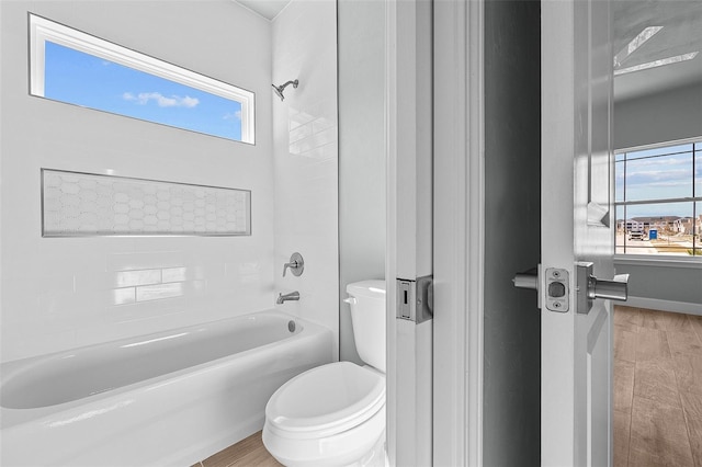 bathroom featuring shower / tub combination, wood-type flooring, and toilet