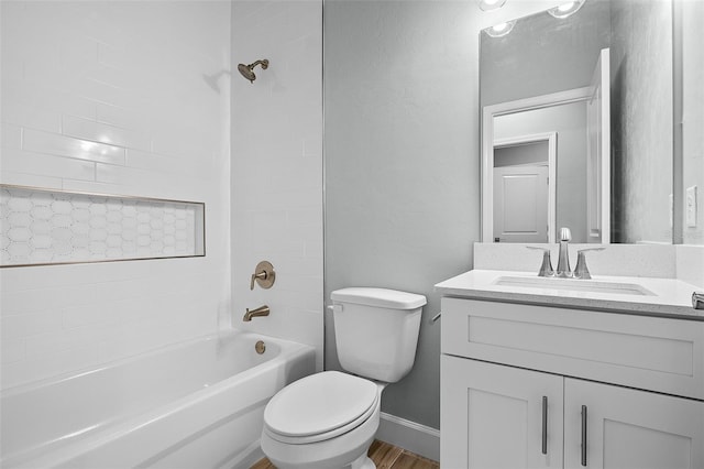 full bathroom featuring tiled shower / bath, hardwood / wood-style flooring, vanity, and toilet