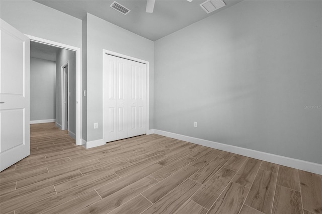 unfurnished bedroom featuring ceiling fan, light hardwood / wood-style flooring, and a closet